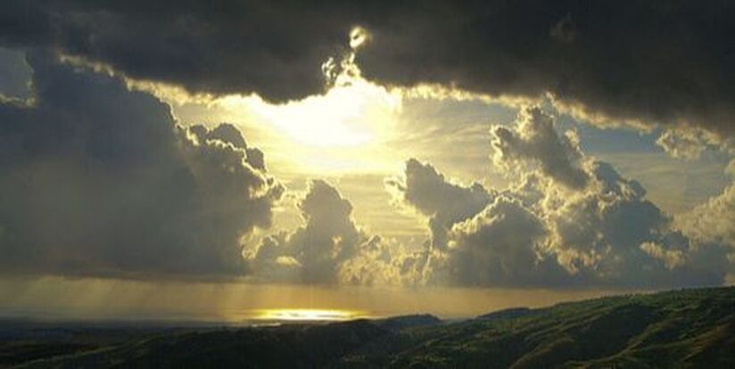 sun breaking through dark clouds